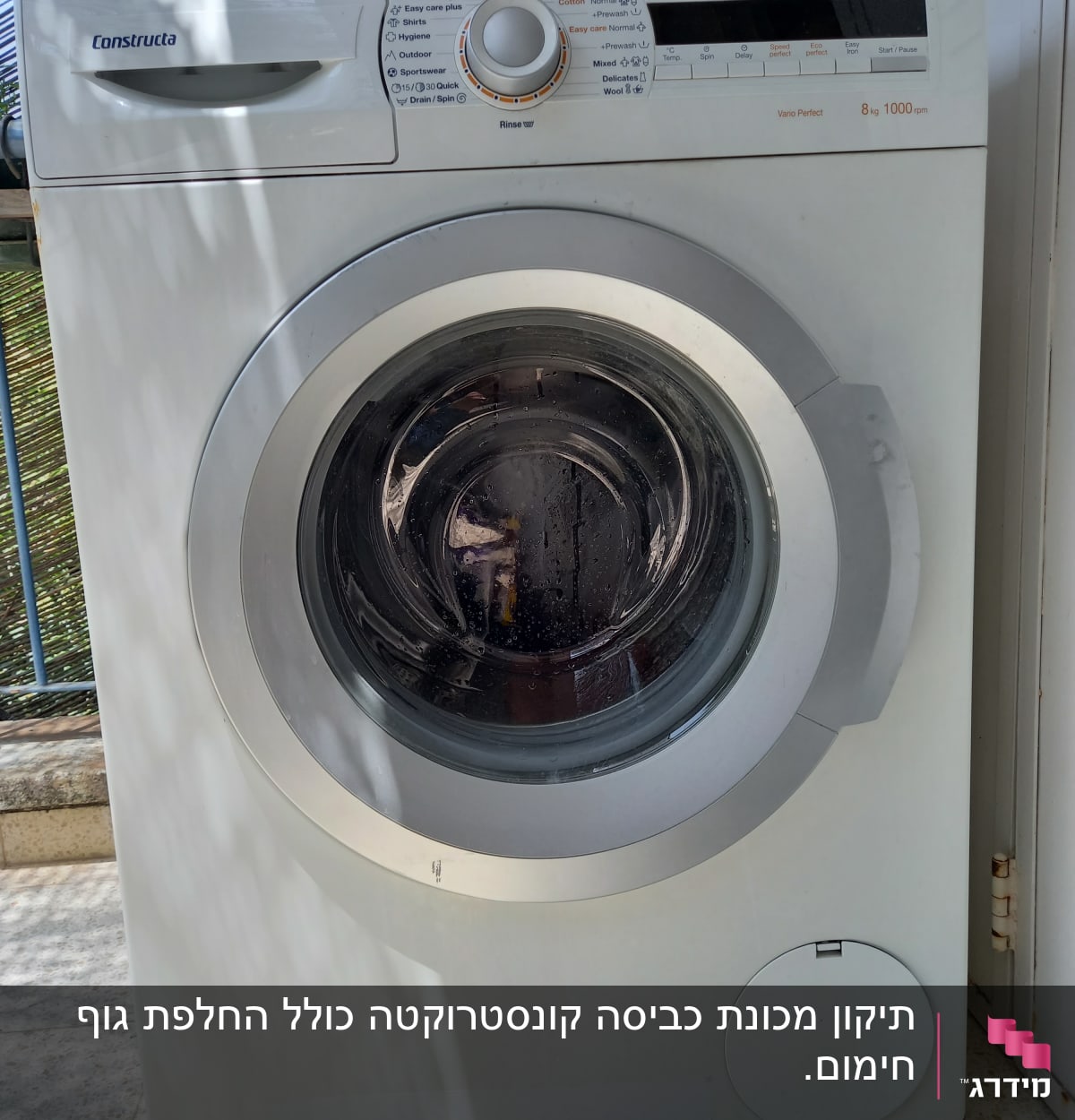 מכונת כביסה לבנה עם כפתורי שליטה ותצוגה דיגיטלית